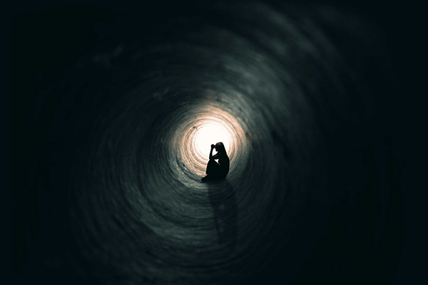 Woman praying in a tunnel