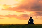 Man sitting watching sunset