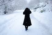 Woman walks through heavy snow