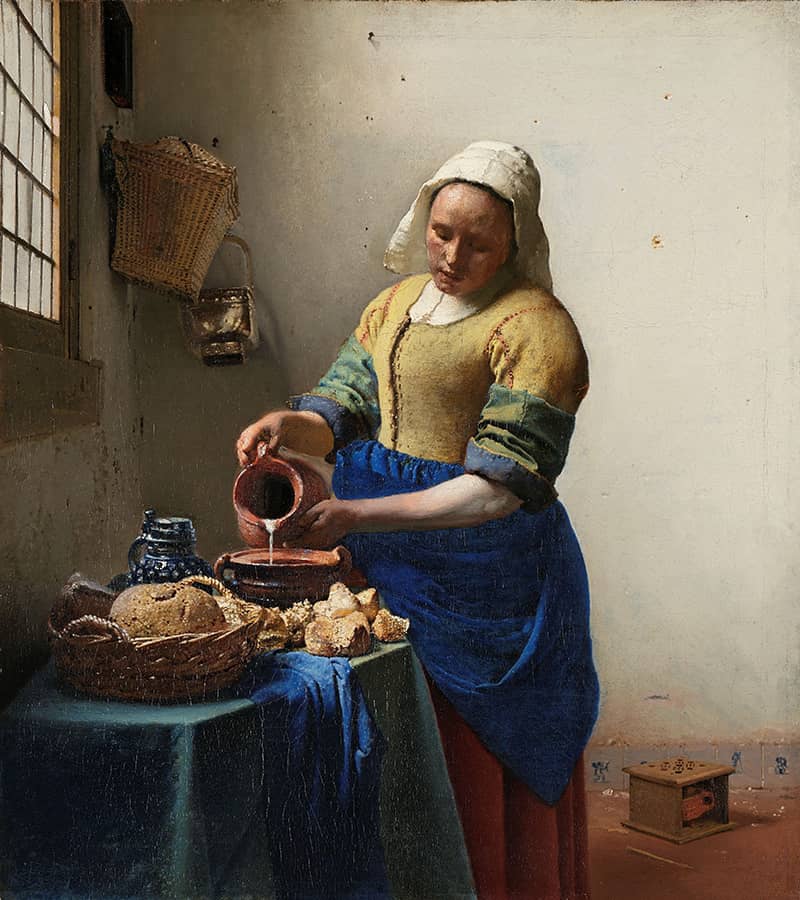 A woman pour milk from a pitcher into a bowl