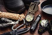 Several different survival kit tools such as rope, boots, a compass, and a flashlight