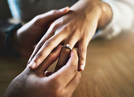 A man placing a ring on a woman's finger