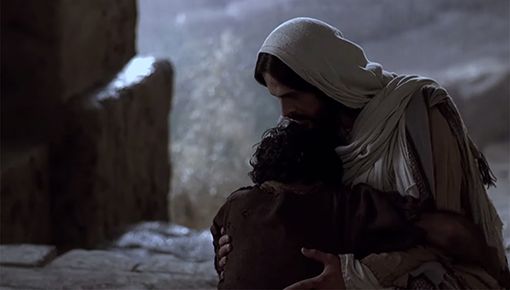 Jesus Christ holding a man crying in his arms