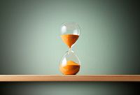 Hourglass with orange sand in it.