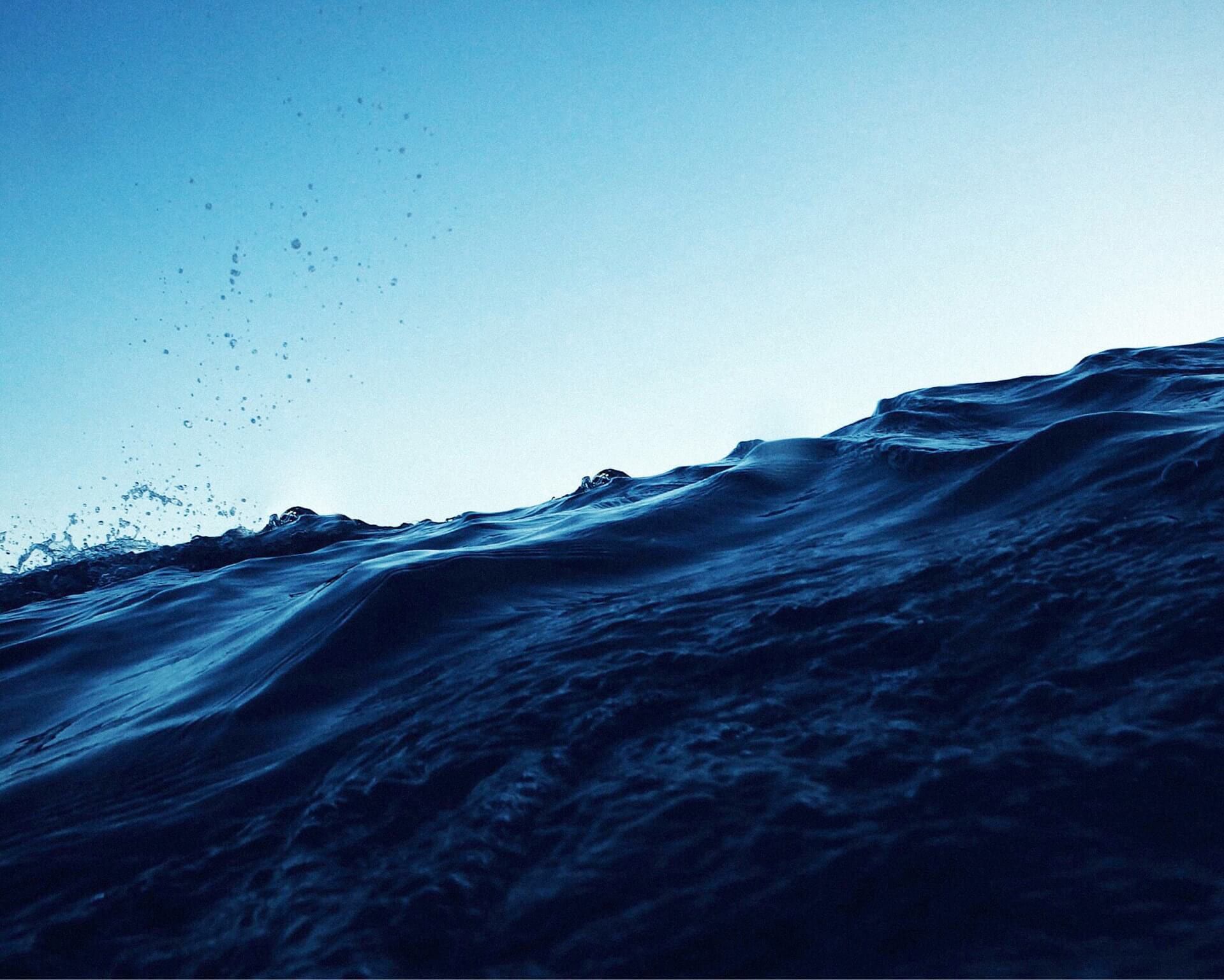 Photo of a deep blue ocean wave against the sky